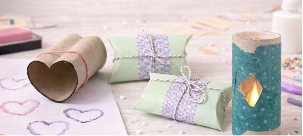 Selbstgemachte Dekorationen und Geschenke aus Klopapierrollen: Eine herzförmige Klorolle als Stempel, kleine Geschenkboxen und ein Deko Windlicht.